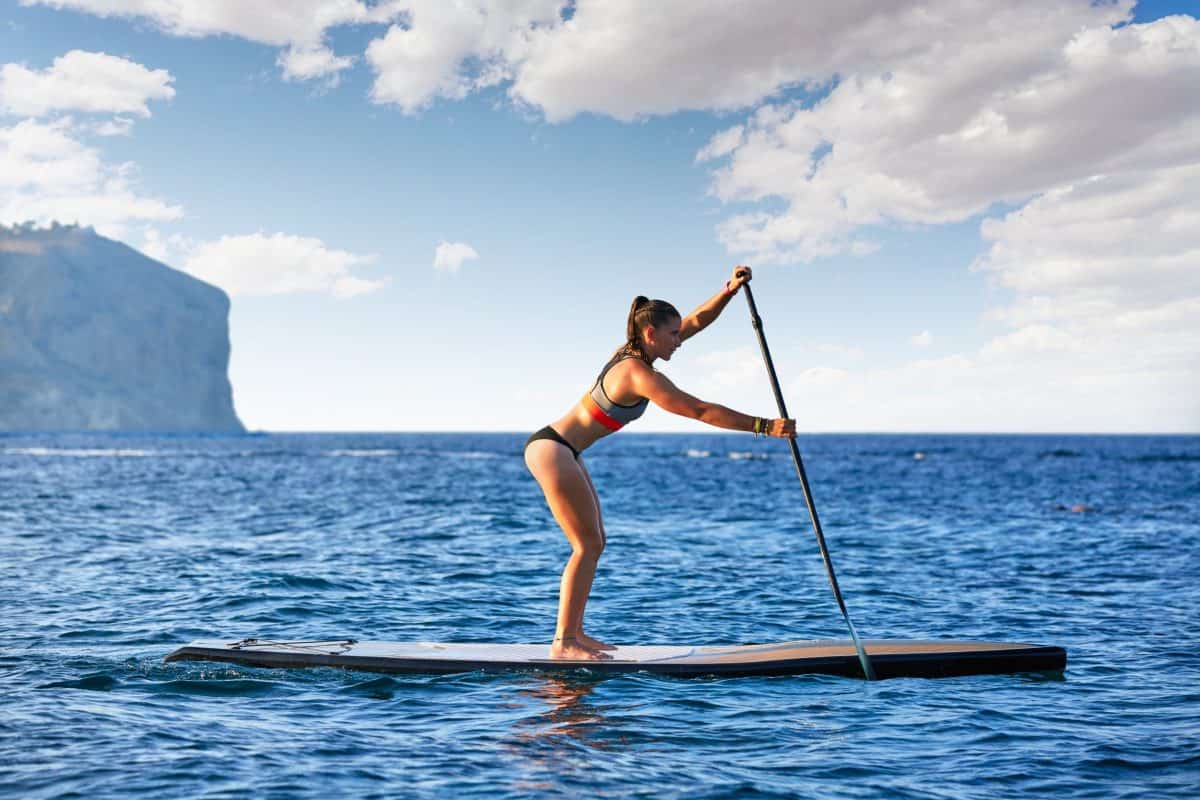 Sup stand up surf girl on hard paddleboard