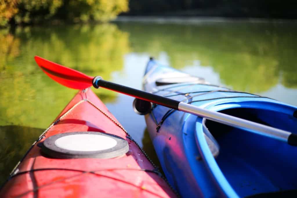 Two colorful kayaks on the river bank