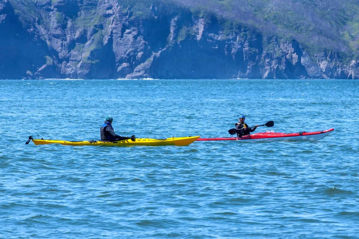 Two Kayakers paddling in the open ocean