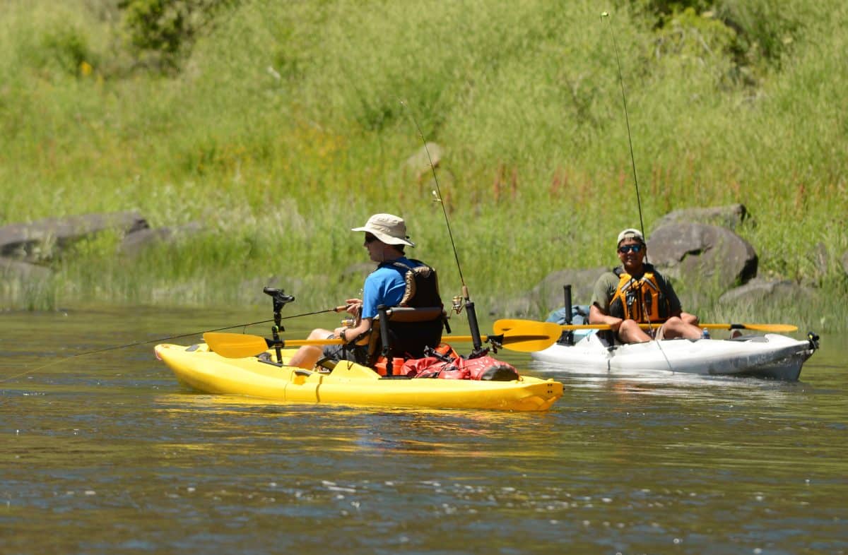 Two men fishing and kayaking in a kayak