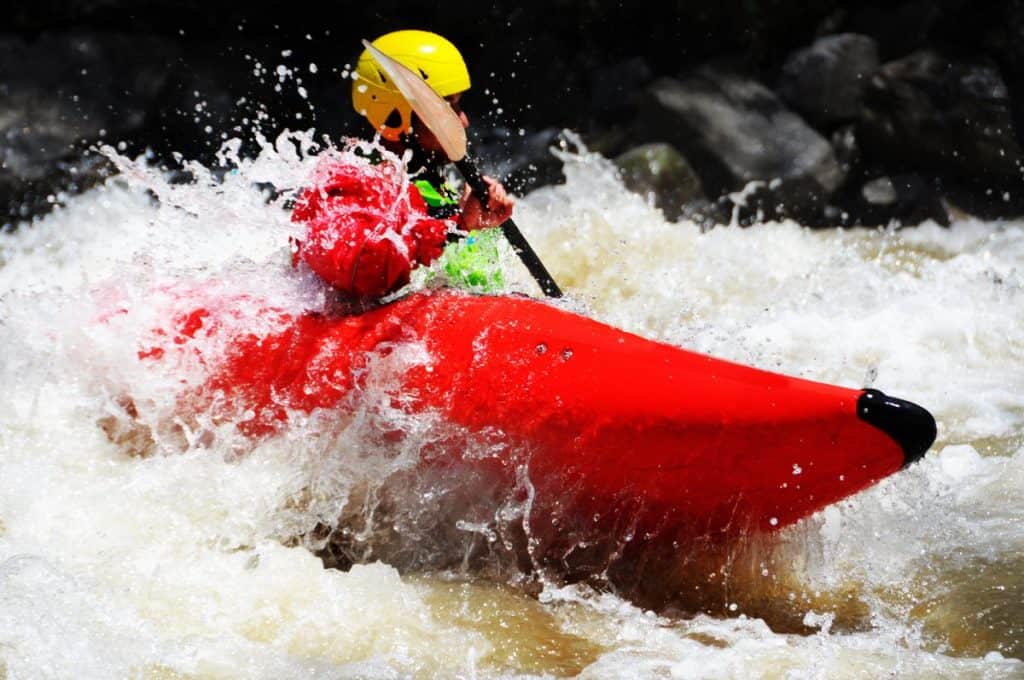 White water kayaker paddling downriver