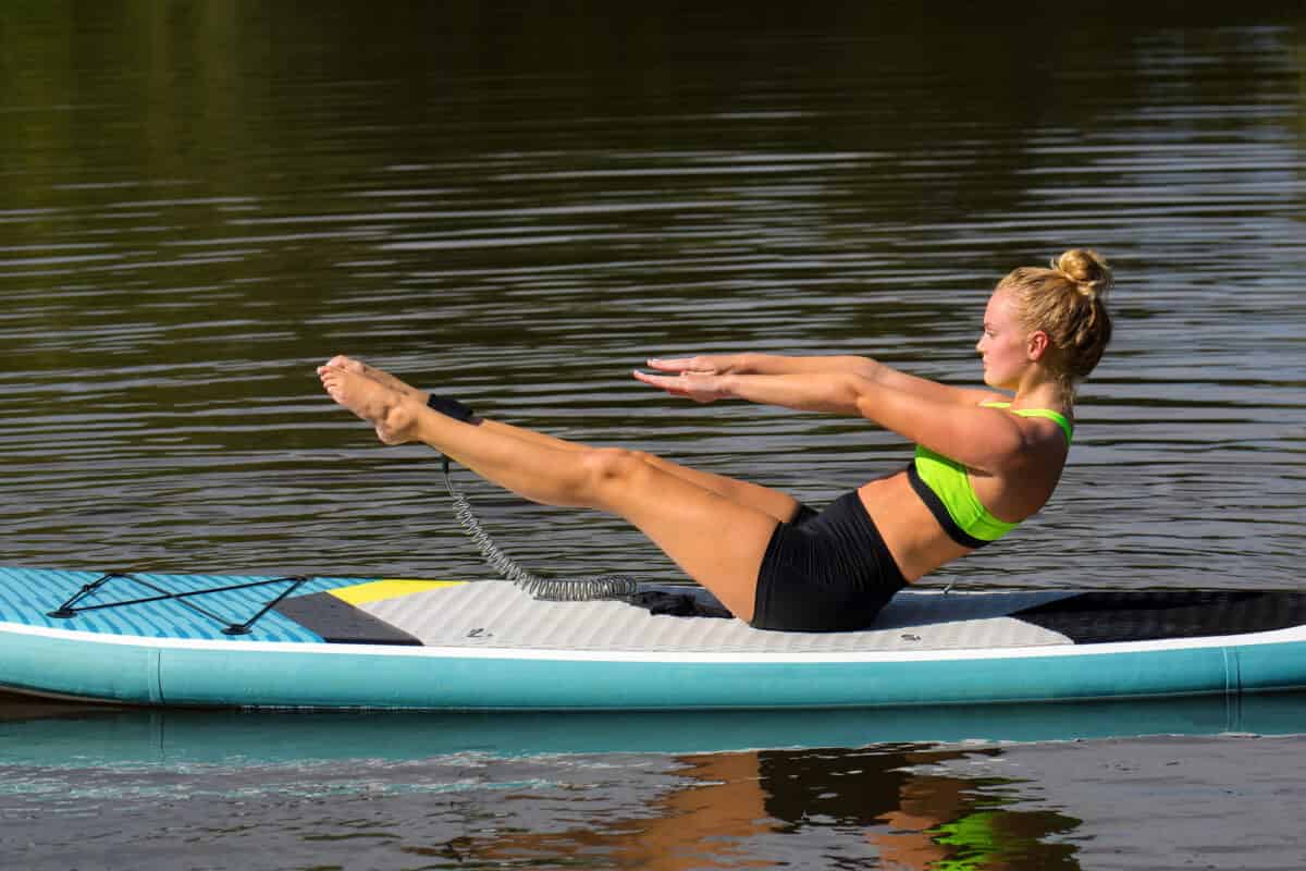 Women performing great exercise for core on stand up paddle board