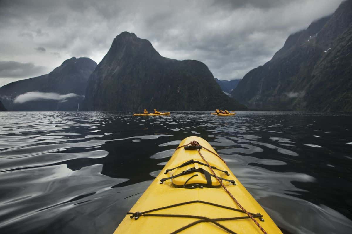 Yellow kayak in open water during a rain storm