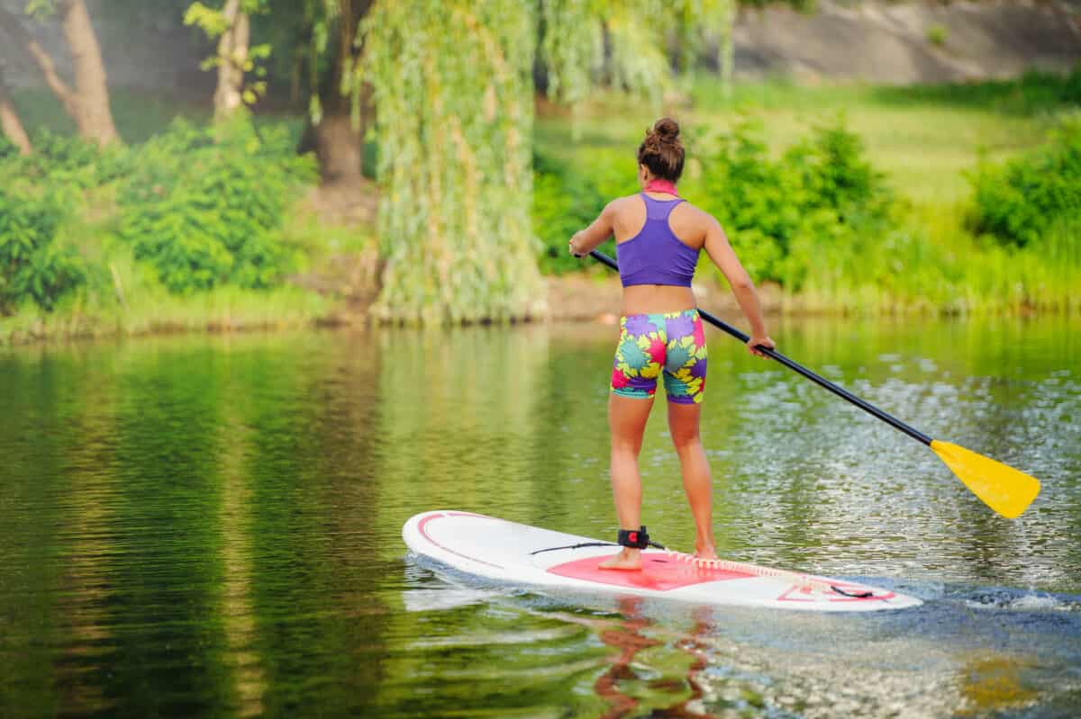 Young athletic woman  on a touring paddle board