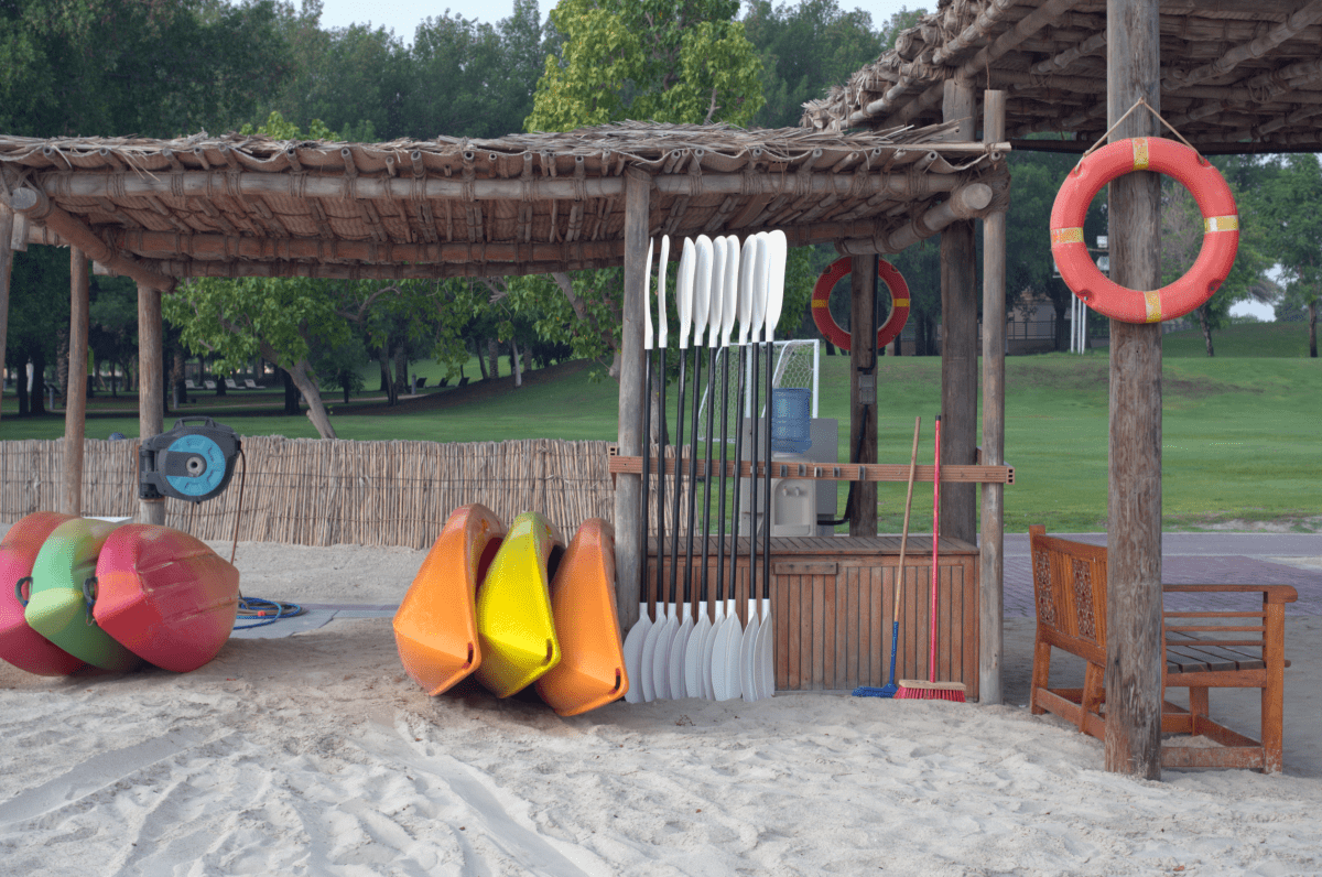 Kayaks of various colors are rented out on the sandy beach
